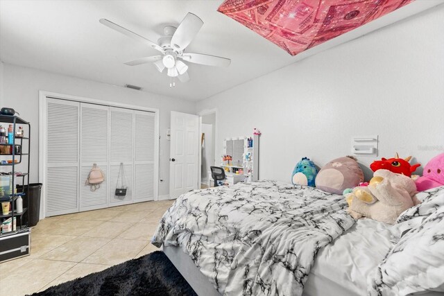 tiled bedroom featuring ceiling fan and a closet