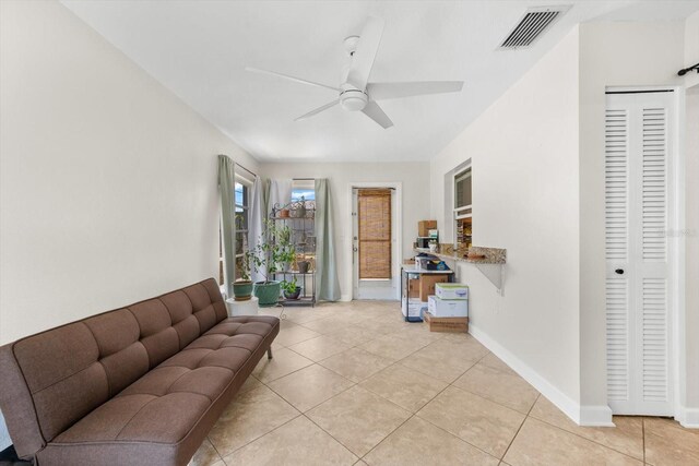 tiled living room with ceiling fan