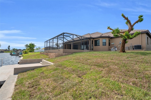 view of yard with a lanai, a water view, and central AC