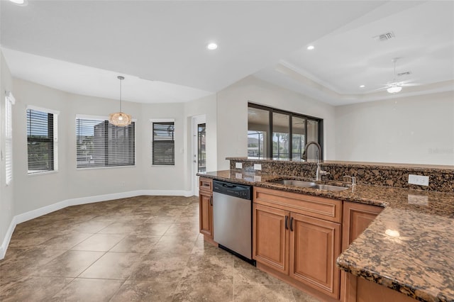 kitchen featuring pendant lighting, dishwasher, dark stone counters, ceiling fan with notable chandelier, and sink