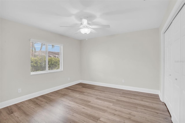 empty room with ceiling fan and light hardwood / wood-style flooring