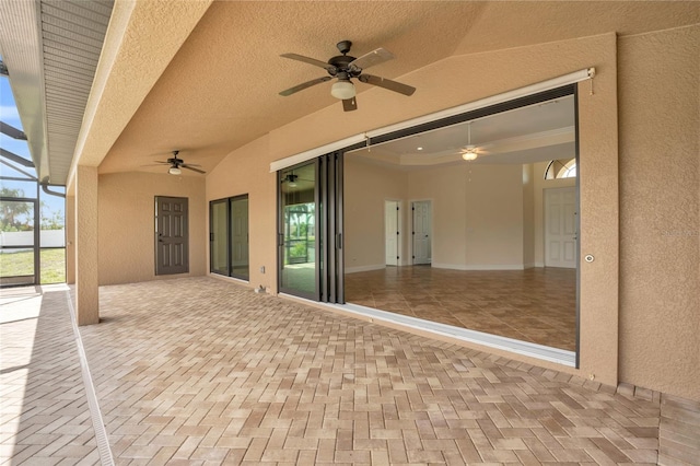 view of patio with ceiling fan and glass enclosure