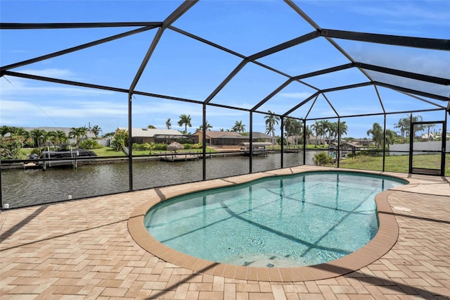 view of pool featuring glass enclosure, a patio area, and a water view