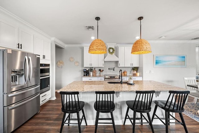 kitchen featuring pendant lighting, white cabinetry, and stainless steel appliances