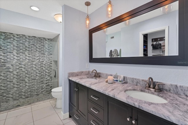 bathroom with vanity, a shower with shower door, and toilet