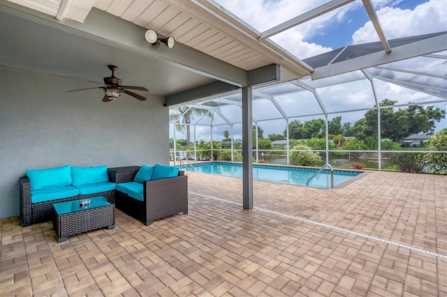 view of pool featuring ceiling fan, outdoor lounge area, glass enclosure, and a patio area