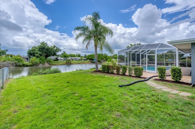 view of yard with a water view and glass enclosure