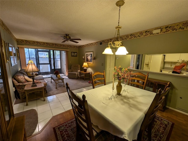 dining room featuring ceiling fan, a textured ceiling, and light hardwood / wood-style flooring