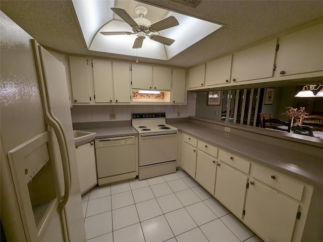 kitchen featuring ceiling fan, white appliances, a tray ceiling, and decorative backsplash