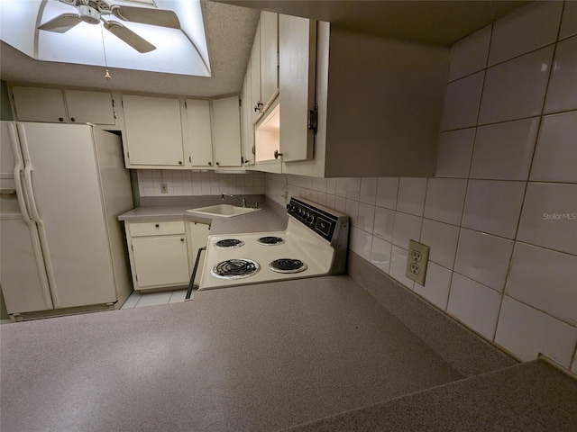 kitchen with sink, white appliances, ceiling fan, white cabinets, and decorative backsplash