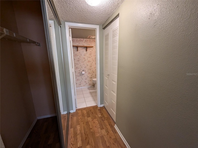 hall featuring hardwood / wood-style flooring and a textured ceiling