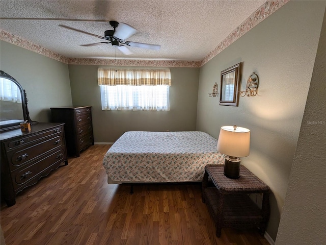 bedroom featuring ceiling fan, wood-type flooring, and a textured ceiling