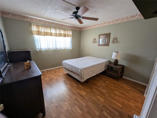 bedroom featuring hardwood / wood-style flooring, ceiling fan, and a textured ceiling