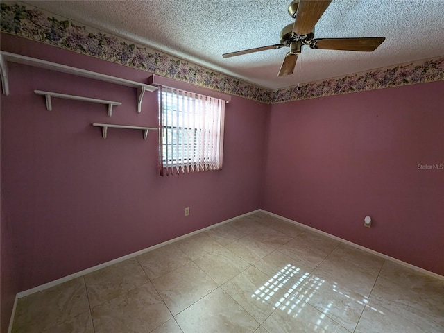 tiled empty room with ceiling fan and a textured ceiling