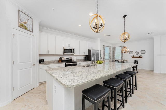 kitchen featuring white cabinetry, sink, decorative light fixtures, a center island with sink, and appliances with stainless steel finishes