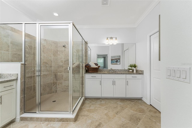 bathroom featuring vanity, a shower with shower door, and crown molding