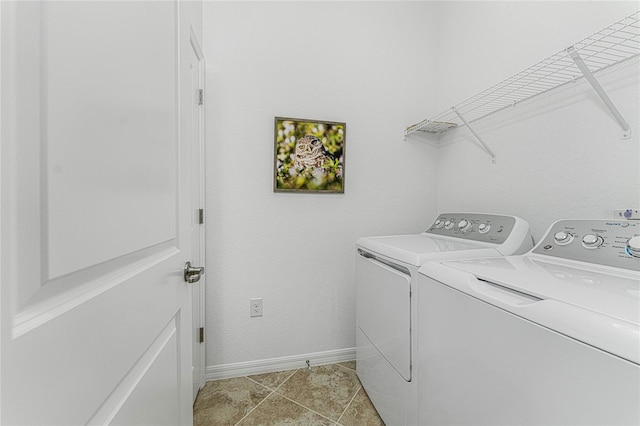 clothes washing area with light tile patterned floors and washer and clothes dryer