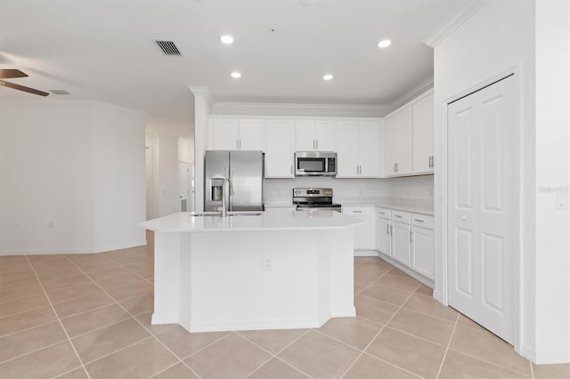 kitchen featuring an island with sink, appliances with stainless steel finishes, and white cabinets