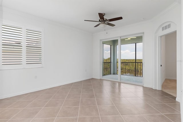 tiled spare room with ornamental molding and ceiling fan