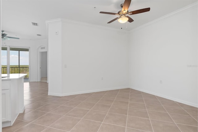 spare room featuring crown molding, ceiling fan, and light tile patterned flooring