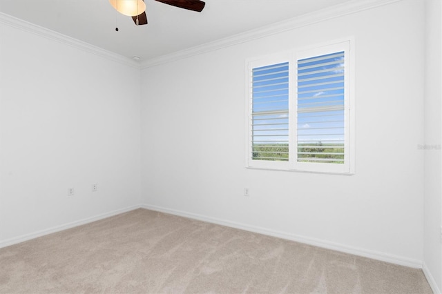 empty room featuring crown molding, light colored carpet, and ceiling fan