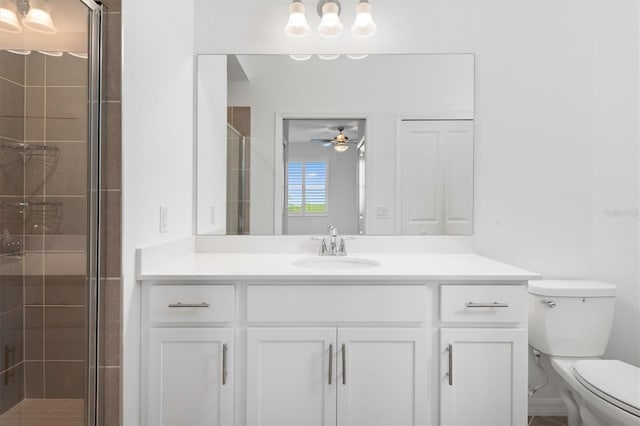 bathroom with ceiling fan, vanity, toilet, and a shower with shower door