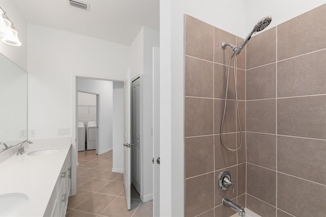 bathroom with tiled shower / bath combo, vanity, separate washer and dryer, and tile patterned floors