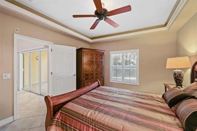 tiled bedroom featuring a tray ceiling and ceiling fan