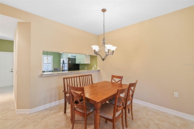 tiled dining room featuring a chandelier