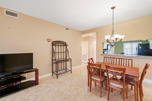 dining space featuring a notable chandelier, light tile patterned floors, and sink