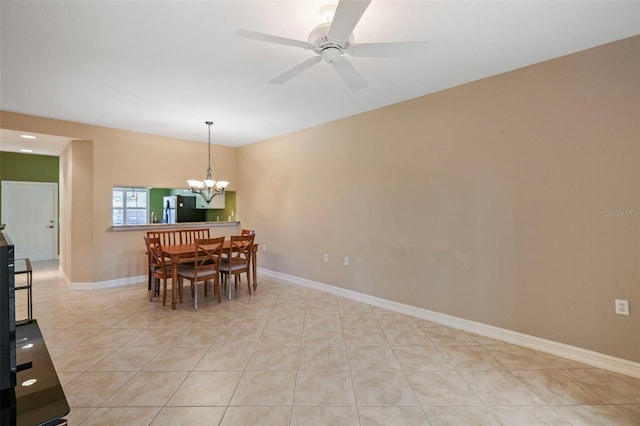 dining room featuring light tile patterned floors and ceiling fan with notable chandelier