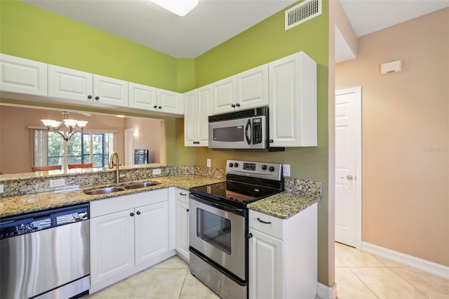 kitchen featuring sink, light stone counters, white cabinetry, and stainless steel appliances