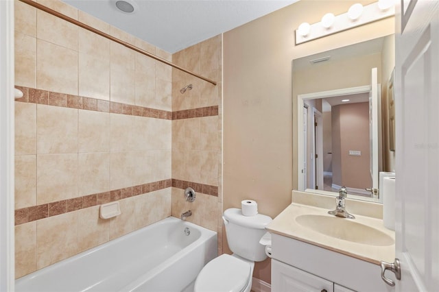 full bathroom featuring vanity, tiled shower / bath combo, and toilet