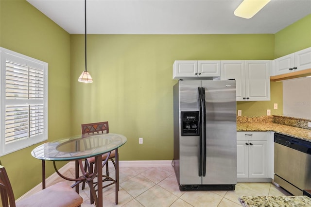 kitchen with hanging light fixtures, light tile patterned floors, light stone counters, white cabinets, and appliances with stainless steel finishes