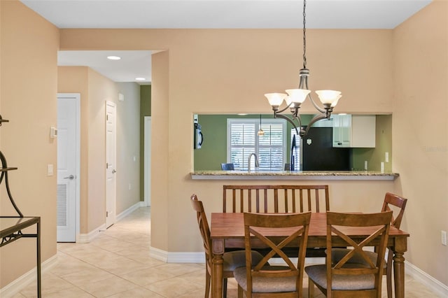 dining room featuring light tile patterned floors, a notable chandelier, and sink