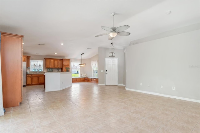 unfurnished living room with ceiling fan, sink, lofted ceiling, and light tile patterned flooring