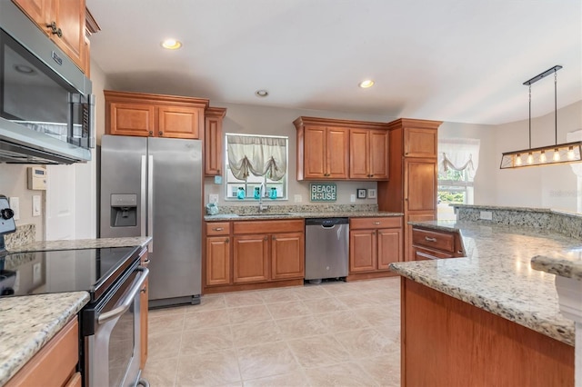 kitchen featuring light stone countertops, stainless steel appliances, sink, hanging light fixtures, and light tile patterned floors