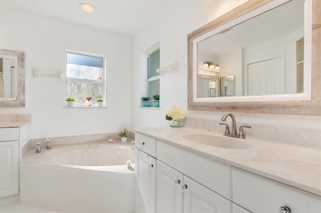 bathroom with vanity and a bath