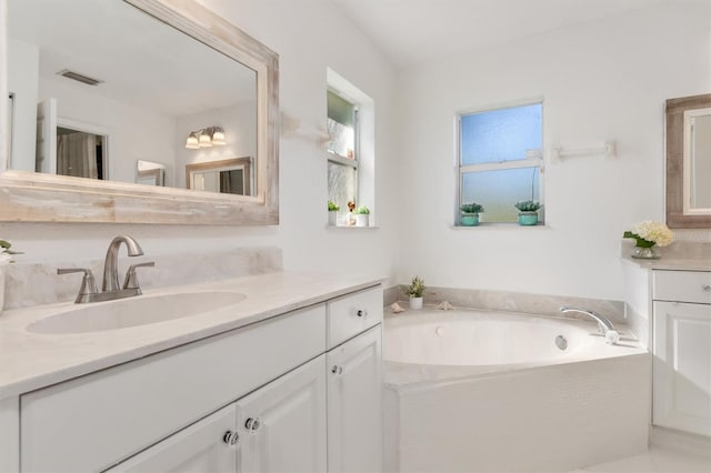 bathroom with a washtub and vanity