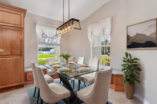 dining room featuring light tile patterned flooring and vaulted ceiling