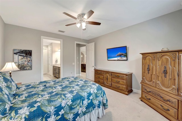 carpeted bedroom with ensuite bath and ceiling fan