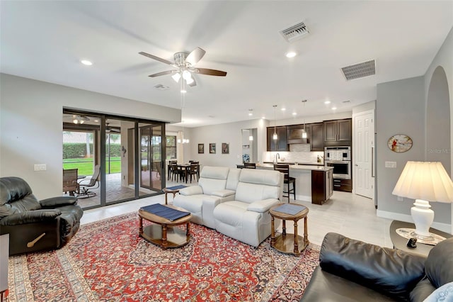 tiled living room with ceiling fan