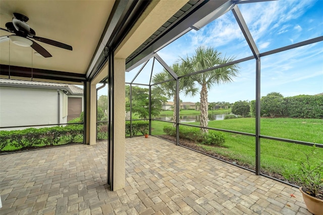 unfurnished sunroom featuring a water view and ceiling fan