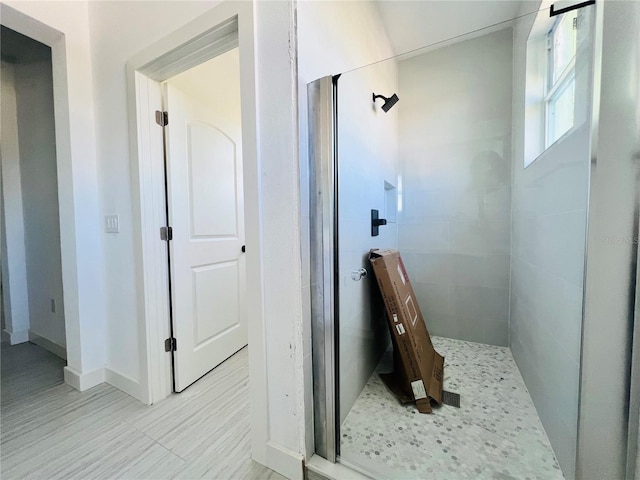 bathroom featuring a shower with shower door