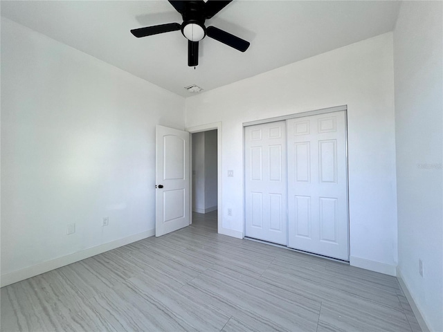 unfurnished bedroom featuring light wood-type flooring, ceiling fan, and a closet