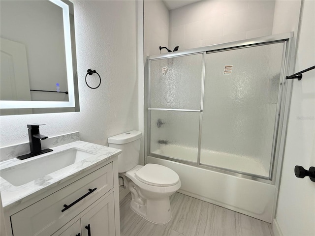 26345 Trinilas Dr, Punta Gorda, FL 33983 - bathroom featuring a textured wall, toilet, shower / bath combination with glass door, and vanity