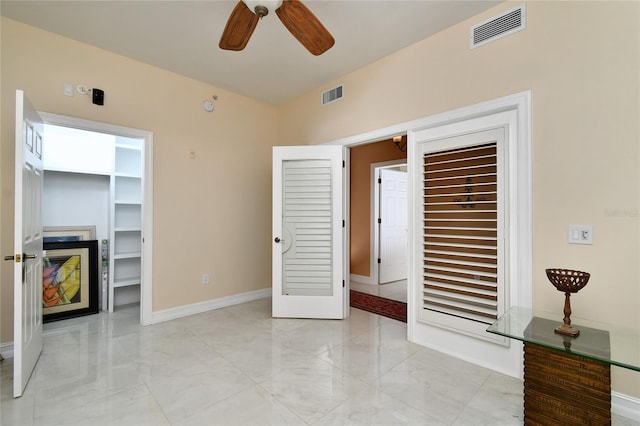 unfurnished bedroom featuring a spacious closet and ceiling fan