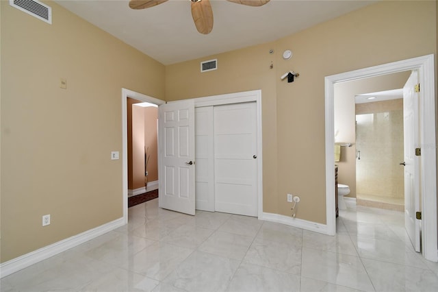 bedroom with ceiling fan, ensuite bath, and a closet