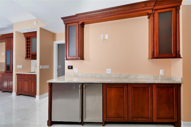 kitchen with fridge, light stone countertops, and light tile patterned flooring