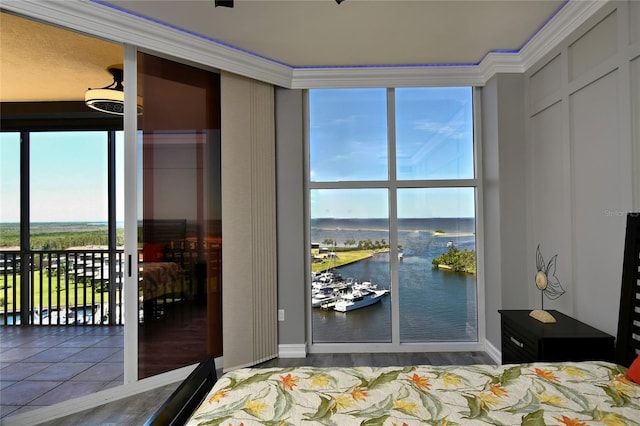 bedroom with a water view and crown molding